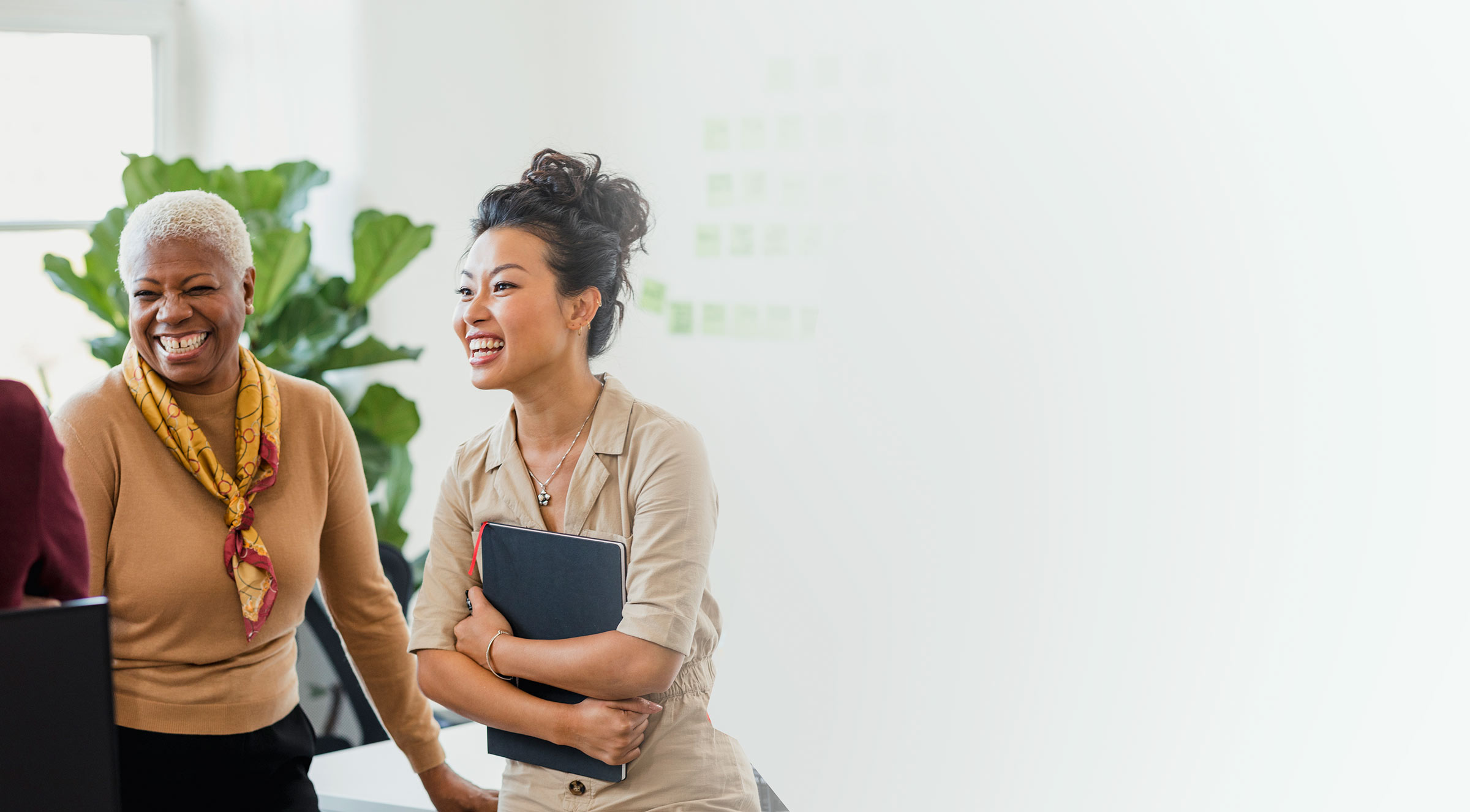 Two HR professionals smile at the third out of frame after learning about Imagine360 health savings